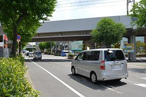 道路を自動車が走行しており、道路の上には高架がかかっている写真