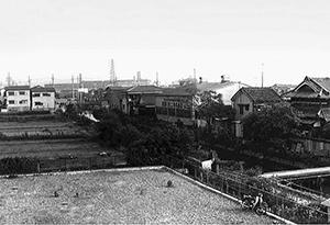 中央から右手に流れる二十箇用水路の周りに住宅街が広がる昔の白黒写真