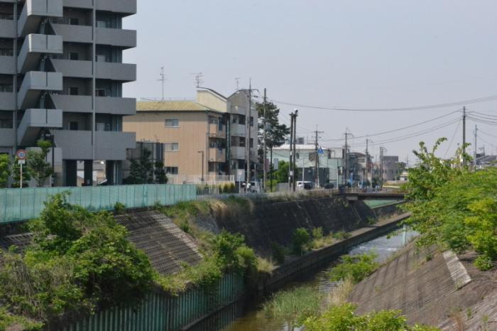 コンクリートブロックの堤防沿いにマンションなどの家が立ち並んでいる現在の写真