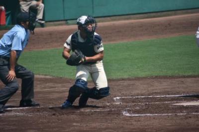 野球の防具を付けて捕手をしている稲富さんの写真