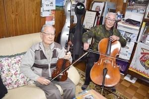 バイオリンを持ってソファーに腰かけている照道さんとチェロを持って椅子に腰かけている孝道さんの写真