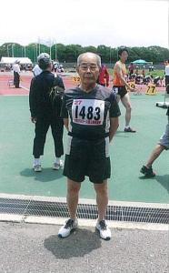 1483番のゼッケンをつけて競技場に立っている吉岡さんの写真