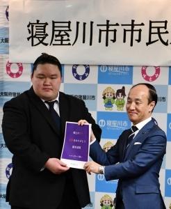 武隈親方と市長が一緒にメッセージ集を持っている写真