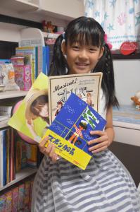3冊の台本を持って笑顔で写っている櫻木綾乃さんの写真