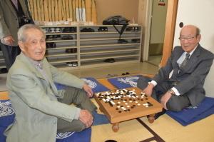 囲碁盤を挟んで写る五十嵐さんと浅野さんの写真