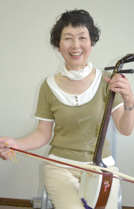関根雅子さんが胡弓を持って笑顔の写真