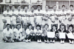 前列に8名の男女が座り、後列に10名の男子がボールを持っている白黒の集合写真
