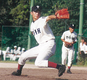 大阪桐蔭高校のユニフォームを着てマウンドに立ち左手にグローブをはめ、右手でボールを投げようと振りかぶっている写真