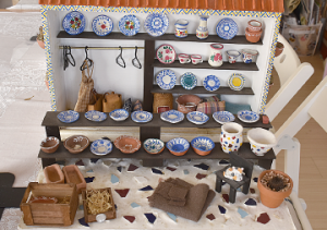 棚やテーブルにスペイン皿がきれいに並べられたミニチュアハウスの写真