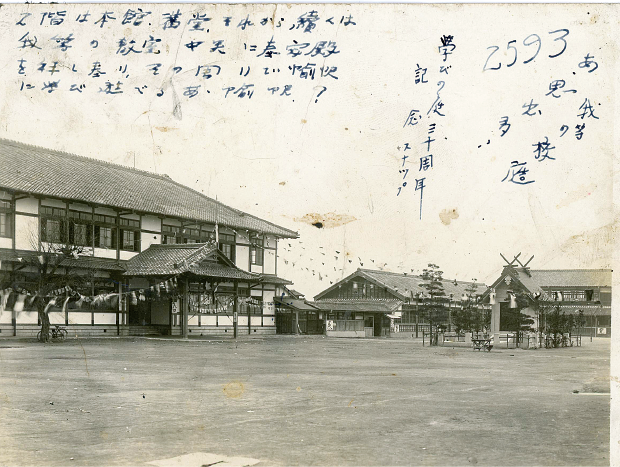 木造2階建ての校舎と校舎の前に広がる運動場の白黒写真