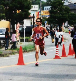 ユニフォームに身をまとい、目にはサングラスをかけて力走している岡村輝将さんの選手時代の写真