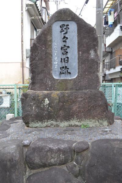 野々宮旧跡碑が建てられており、後方には緑色のフェンスが設置され住宅やアパートが写っている写真