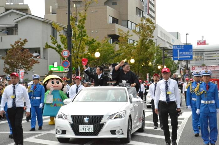 パレードの車に豪栄道関と市長が乗り、沿道のお客様に手を振っている写真