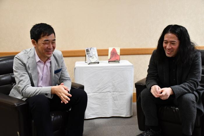 黒色のソファーに座り笑っている又吉直樹さんと門井慶喜さんの写真