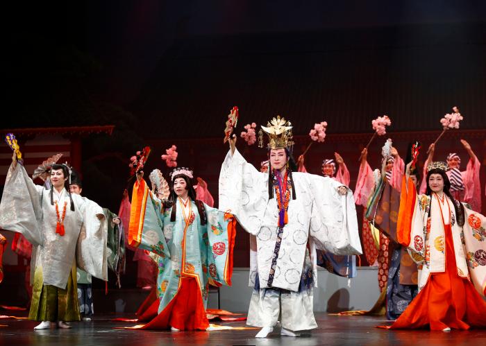白色や水色オレンジ色などの様々な衣装を身にまとい、手には扇子や飾り物を持っている日本歌劇団の方々の写真
