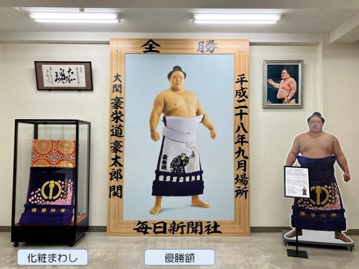 寝屋川市役所1階ロビーに飾られている武隈親方の優勝額、化粧まわし、等身大パネルの画像
