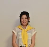 黄色いセーターを首に巻いている執行 悠里さんの写真