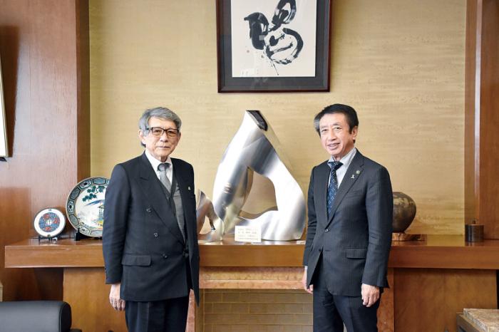 ステンレス製で作られた作品の両隣に立っている野村さんと北川市長の写真