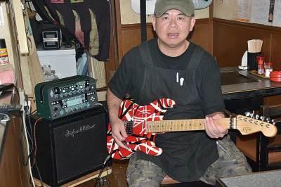 ギターを弾いている米田喜一さんの写真