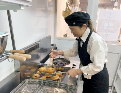手裏剣形の印が入った伊賀牛すじカレーパンを揚げる花山さん