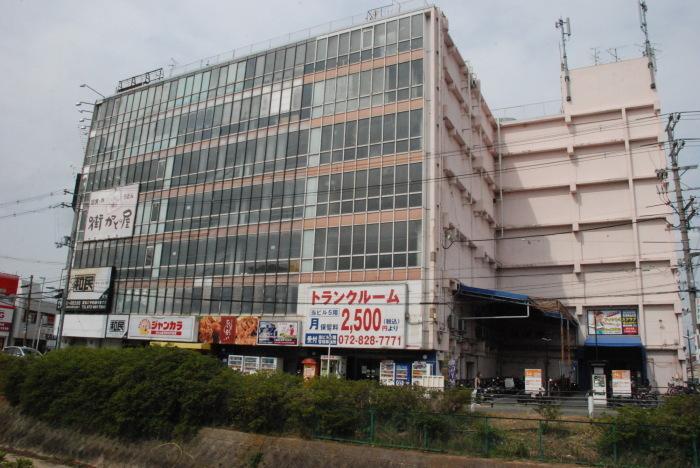 昔、寝屋川市警察署があった場所に大きな建物が立っています。川沿い側は全面窓ガラスのビルがある今の写真