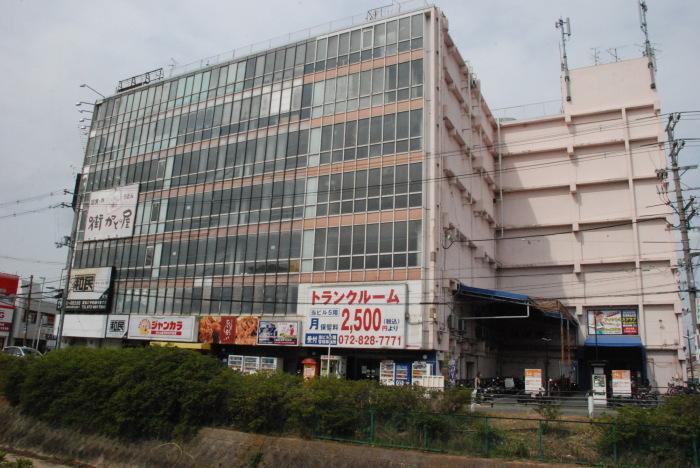 昔、寝屋川市警察署があった場所に大きな建物が立っています。川沿い側は全面窓ガラスのビルがある今の写真