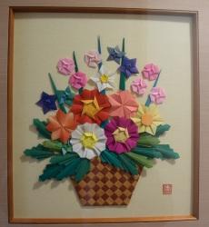 折り紙でお花を作り額に飾られている写真