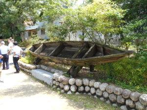 植え込みに設置されている古い木製の船の写真