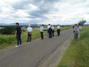 道路沿いに立って淀川河川公園を眺めている参加者の写真