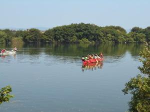 川の中央に、Eボートの体験を行っている参加者がEボートに乗っている写真