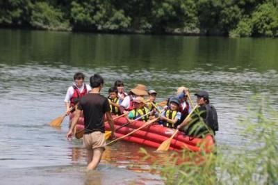 淀川でライフジャケット来た体験者達がカヌー乗船体験する写真