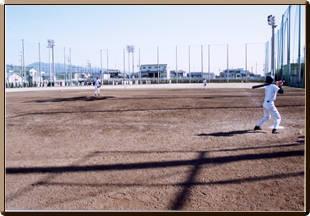 市民グラウンドでユニホームを着た選手が野球をしている写真