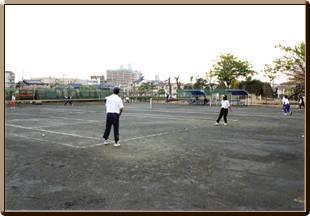 田井西公園テニスコートでテニスをしている人々の写真