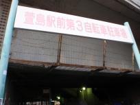 「萱島駅前第3自転車駐車場」と文字の書かれた看板が駐車場の入口に立てられている写真