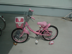 ピンク色の幼児用（補助輪付き、18インチ ）の自転車