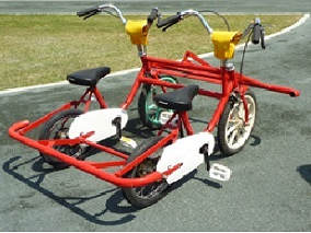自転車が横に2台繋がっており本体が赤色の仲良しツインサイクルの写真