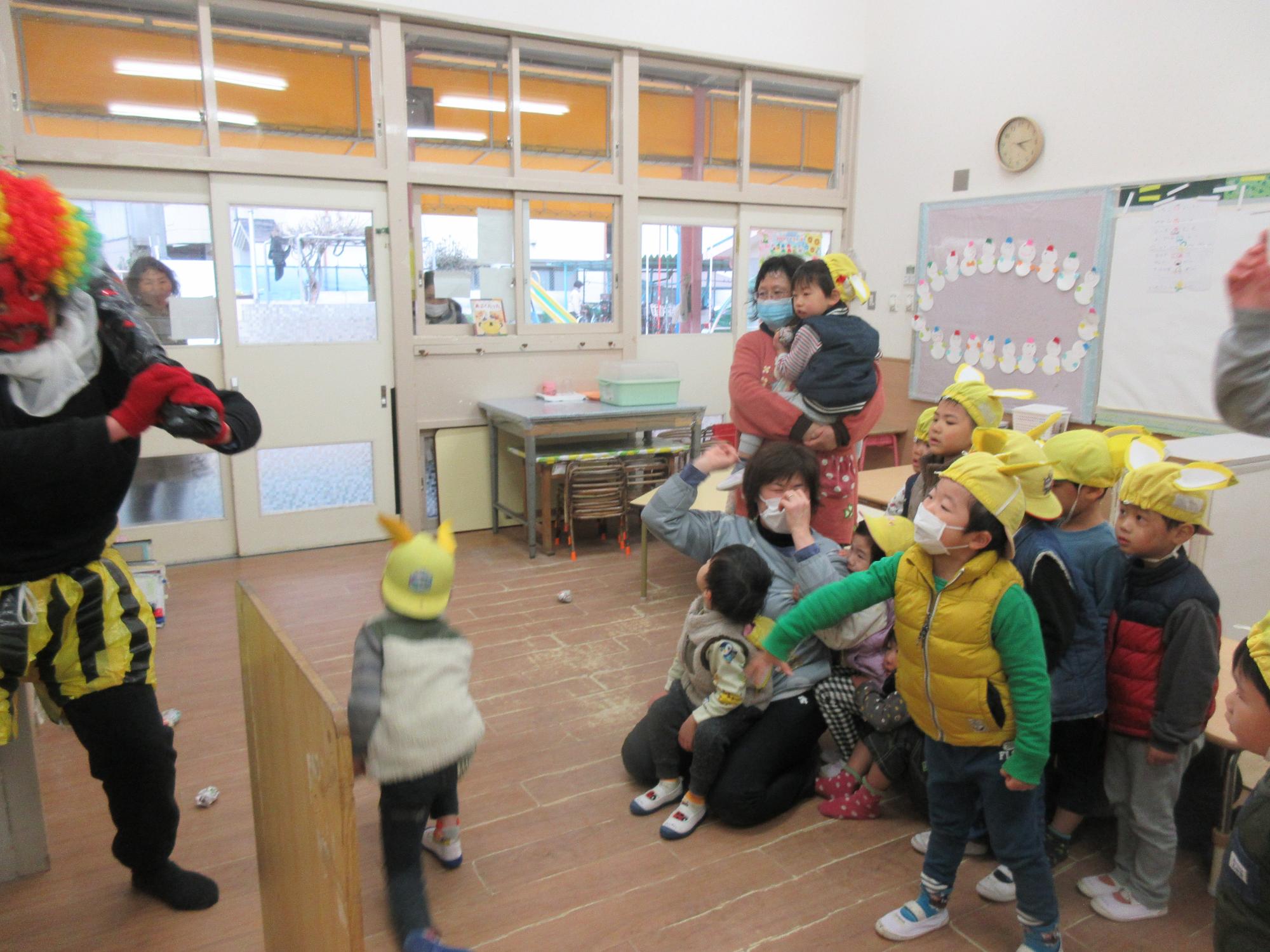 黄組（3歳児）がオニに豆を投げている様子