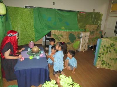 赤い髪の毛の女性の前で4人の子供たちが丸いボールの様なものを握っている写真