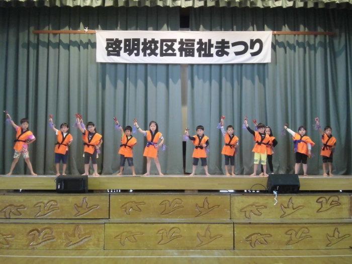 福祉祭りの舞台でオレンジの法被を着て踊りを披露している白組さんの写真