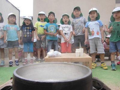 釜戸で炊いたご飯を見て歓声とあげる子供たちの写真
