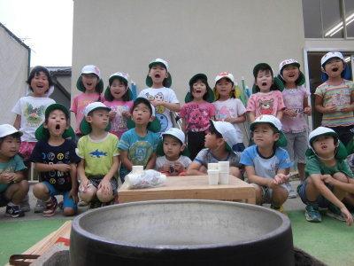 炊きあがった釜戸のご飯をみて驚いた表情を見せる子供たちの写真