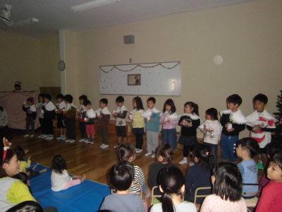 白組の子供達が1列に並び歌を披露しているクリスマス会の写真
