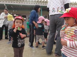シャボン玉を吹いている2人の1歳児の写真