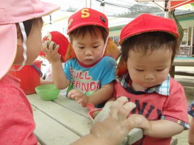 下のほうを向いている赤い帽子をかぶった2人の子供の写真