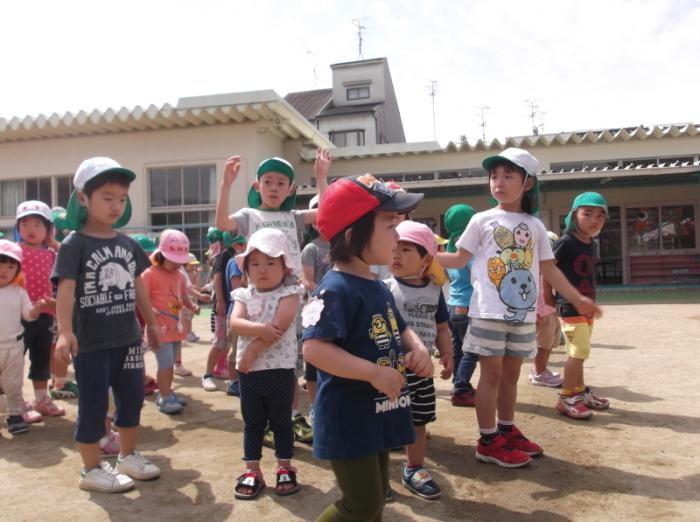 園庭に集まった2歳児クラスの子供たちと体験保育に参加した子供たちの写真