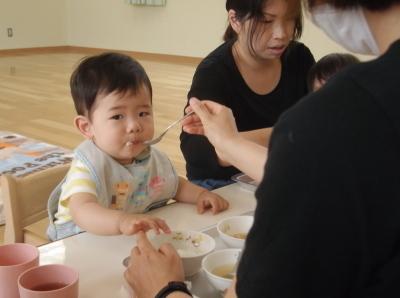 母親に離乳食を食べさせてもらっている子供の写真