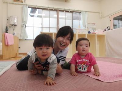 2人の赤ちゃんと笑顔の研修の先生の写真