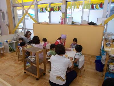 しっかりと椅子に座り給食を食べる子供達の写真