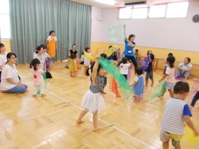 緑色の生地で子供達が遊んでいる写真