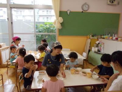 テーブルを囲み、給食を体験する子供達の写真